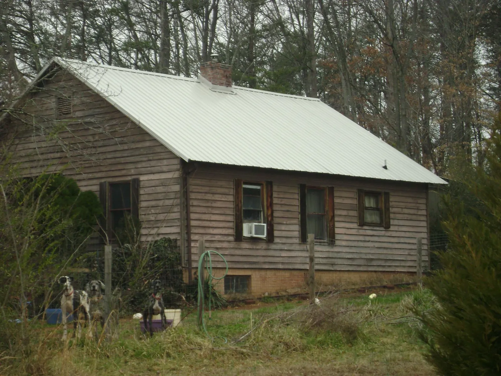 White metal roof on an old wood sided farmhouse, from a Metal Roof Installation job in Watertown